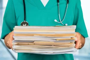 A close up of a doctor holding file folders