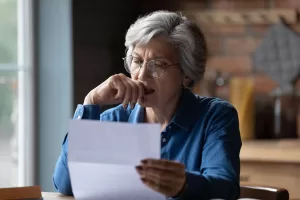 A woman anxiously looking at paperwork