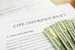A life insurance policy with US currency sitting on top of it